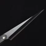 Close-up of the Tyndareus stainless steel knife blade with black coating, emphasizing its superfine stainless steel material and sharp edge.