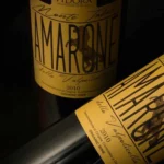 Amarone della Valpolicella DOCG organic wine paired with aged cheeses and braised meat on a rustic table.