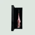 The open box of Armand De Brignac Rosé Champagne, showcasing the bottle and intricate packaging design.