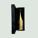 Armand De Brignac Brut Gold Champagne bottle alongside its elegant black and gold gift box.