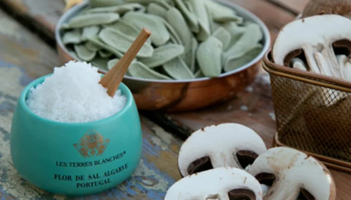 Elegant ceramic jar of organic salt beside fresh herbs Elegant ceramic jar of organic salt beside fresh herbs