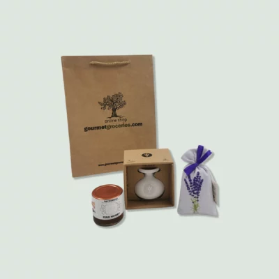 A set of gourmet items including a brown paper gift bag, a jar of marjoram seasoning, a bottle of olive oil in a box, and a fabric bag of lavender. The gift bag has a rope handle and the logo "gourmet2.wearedoubledot.com" printed on it.