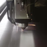 Laser engraving tool personalizing a bread knife handle at the Claude Dozorme workshop, combining tradition with modern techniques