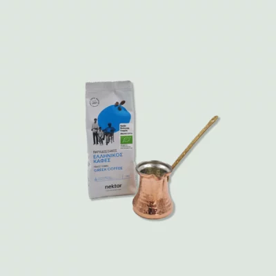 A package of Nektar Traditional Greek Coffee and a copper cezve with a long handle. The coffee package is white with blue accents, and the cezve has a hammered texture.
