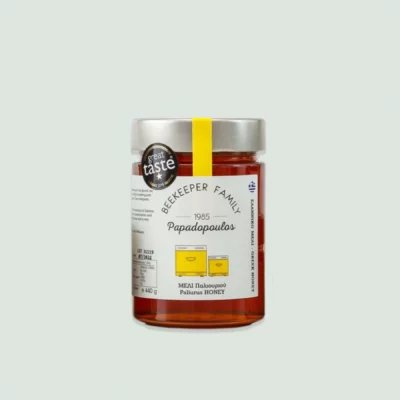 A close-up of the organic Paliouri honey bottle showcasing its vibrant label and golden honey inside.