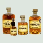Four bottles of Spyropoulos Aged Tsipouro arranged together. This premium spirit is aged in oak barrels, offering a refined and complex flavor profile.