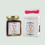A jar of Vasilissa Wildforest Honey showcasing its rich amber color and elegant label, symbolizing premium organic honey.