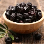 Black Cypriot olives served in bowl with Mediterranean herbs